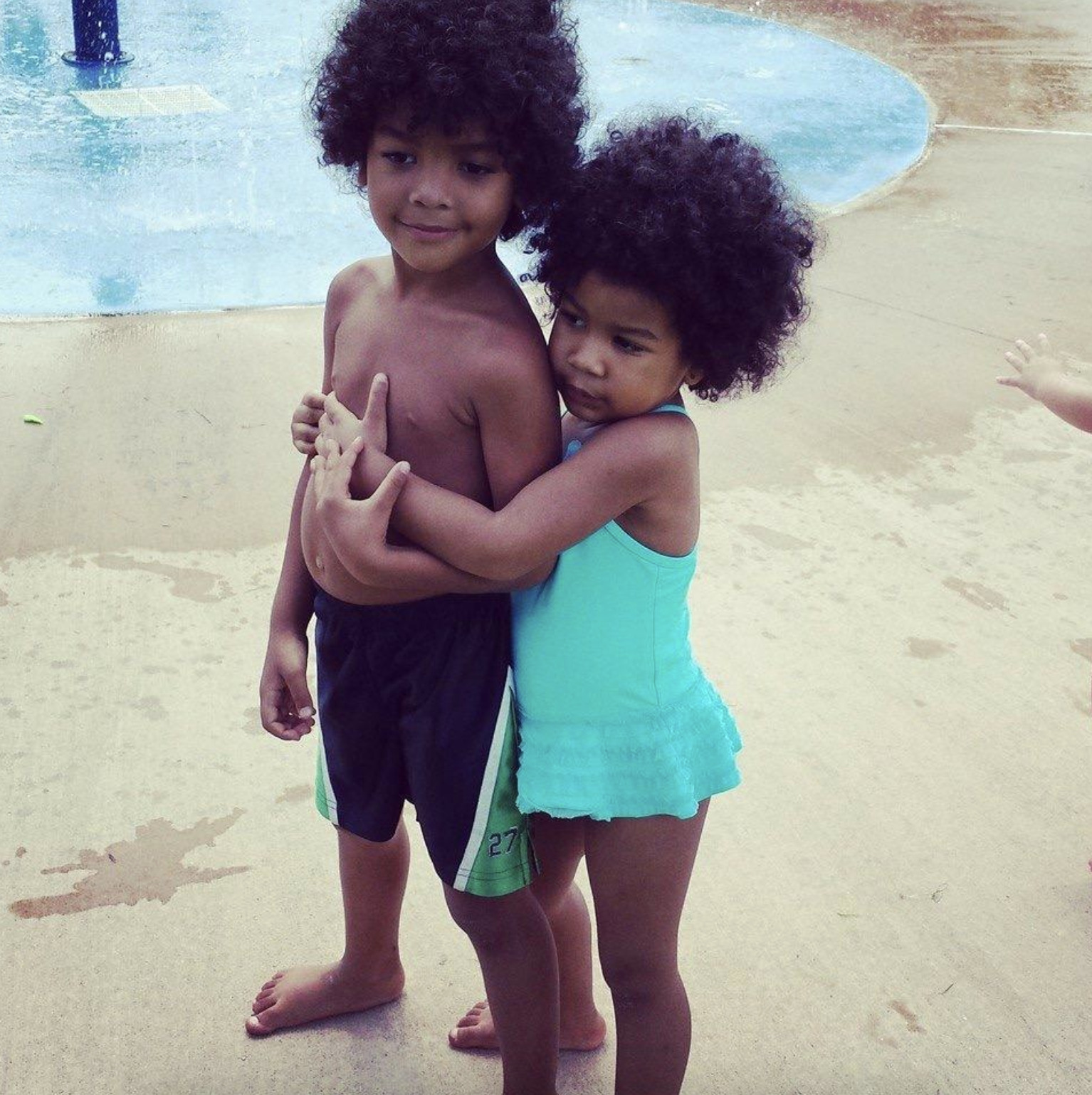 Siblings smiling by pool