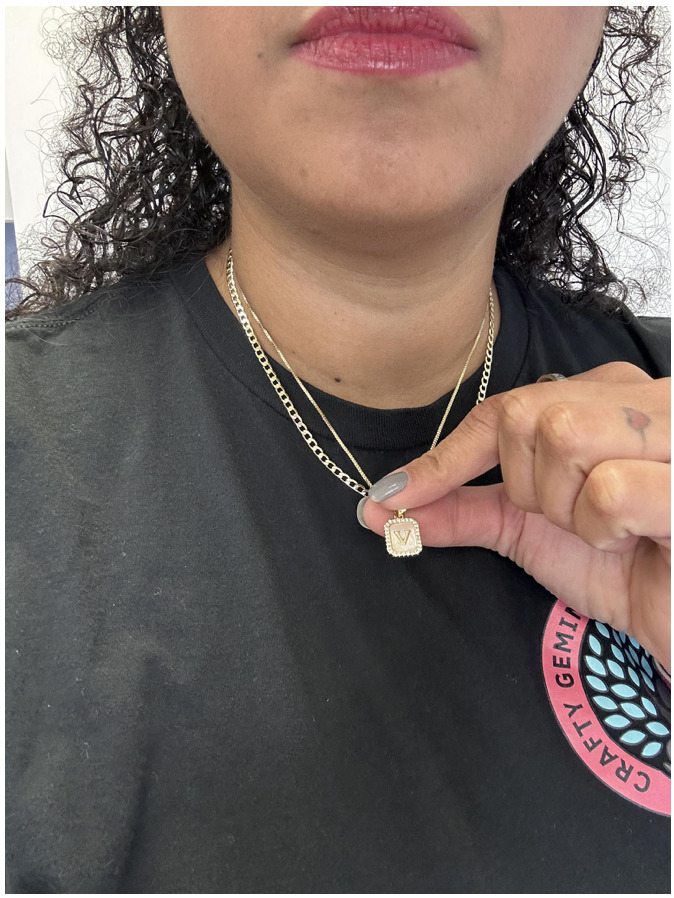 Vanessa showing gold V necklace