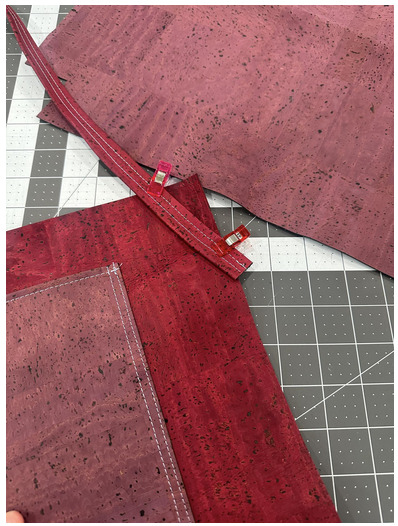 Red cork fabric pieces mid-project on a work table